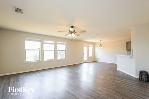 A spacious room with a ceiling fan and wooden flooring.