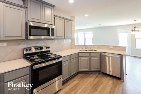 A kitchen with a stove top oven and microwave.