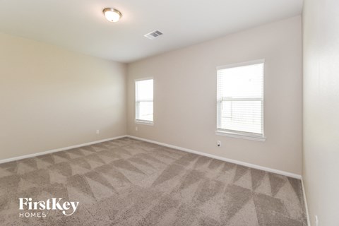 the upstairs bedroom with carpeted flooring and two windows