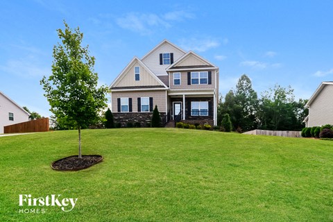 a large lawn in front of a house with a tree