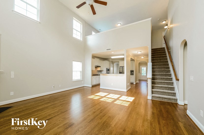 a living room with a staircase and a ceiling fan