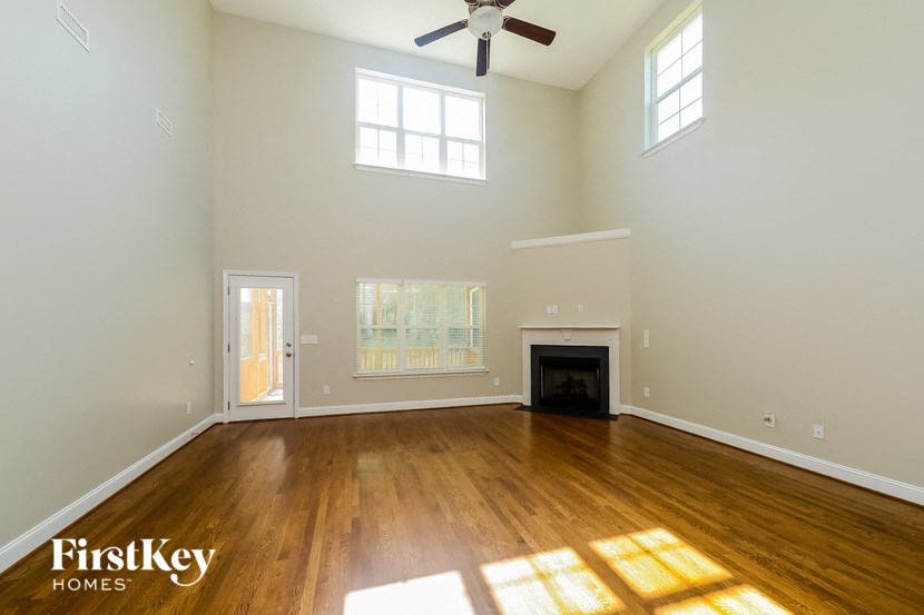 an empty living room with wood floors and a fireplace