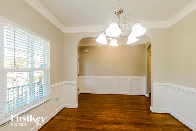 an empty dining room with a large window and white walls
