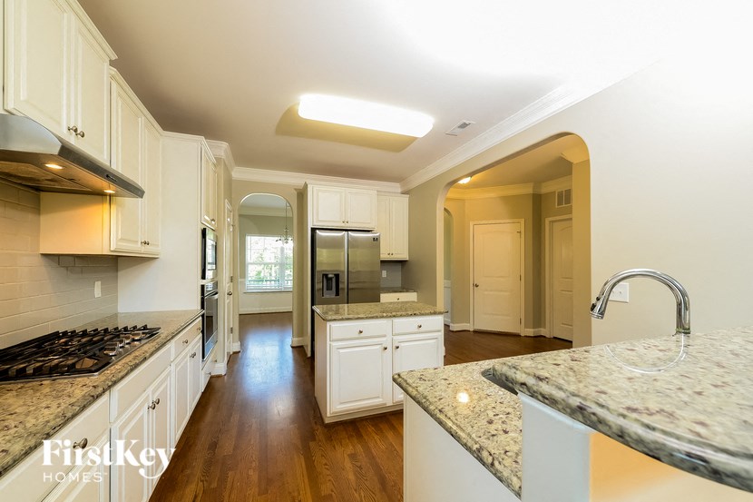 a kitchen with white cabinets and granite counter tops