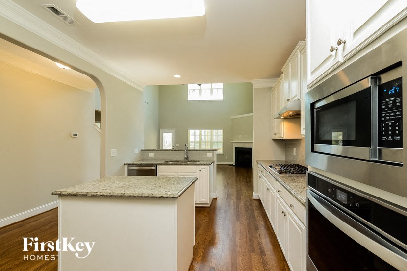 a large kitchen with white cabinets and stainless steel appliances