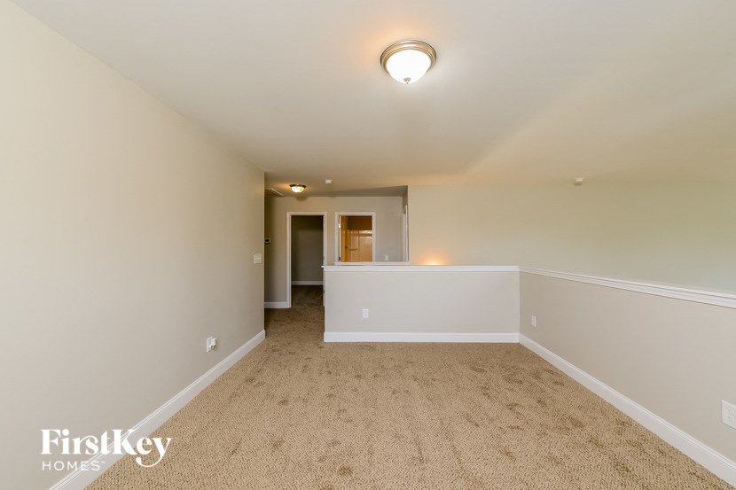 a spacious living room with beige carpet and white walls