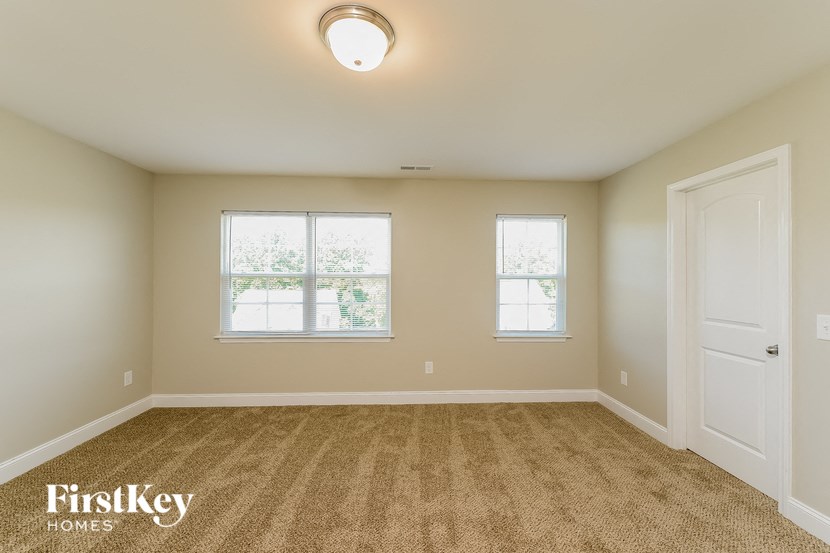 an empty room with two windows and a door