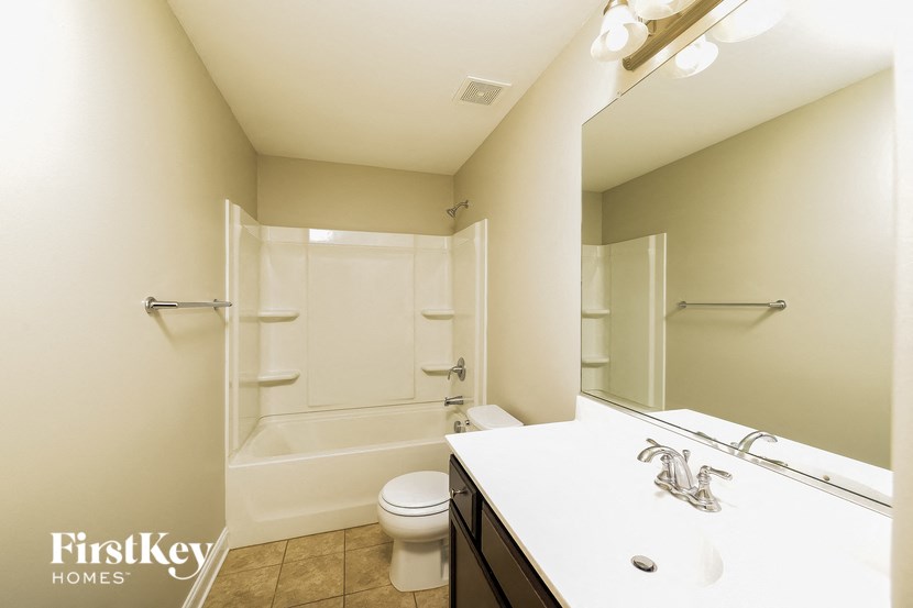 a bathroom with a shower toilet and sink and a mirror