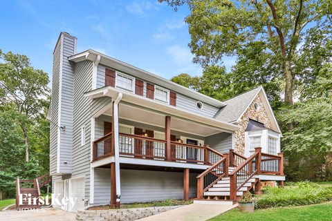 the front of a house with a porch and a deck