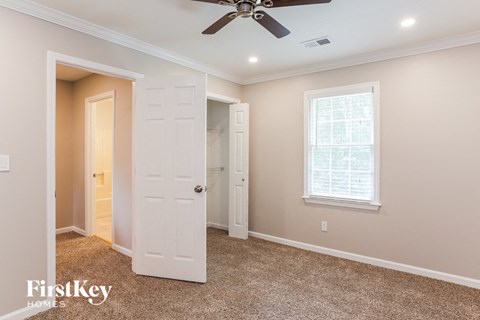 an empty bedroom with a ceiling fan and a closet