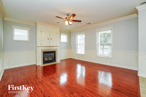 A room with a fireplace and wooden floors.