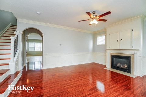 A spacious room with a fireplace and a staircase.