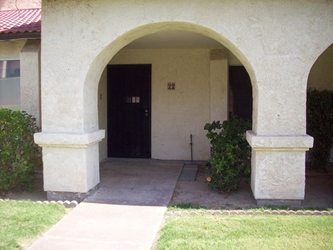 A white building with a black door and number 22 on the wall.