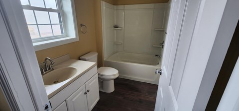 A bathroom with a toilet, sink, and bathtub.