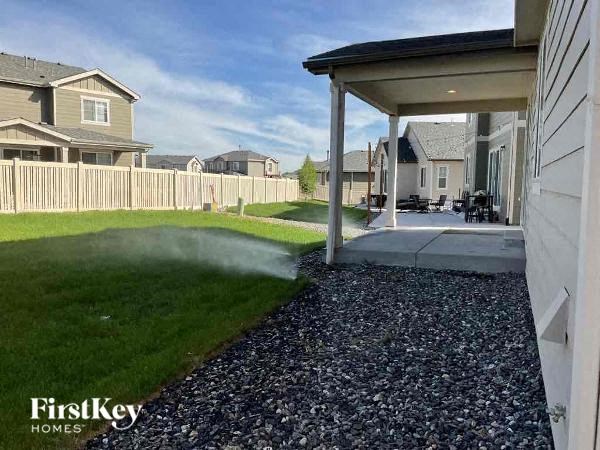 a backyard with a white fence and a house