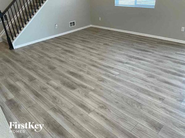 a room with a wooden floor and a staircase