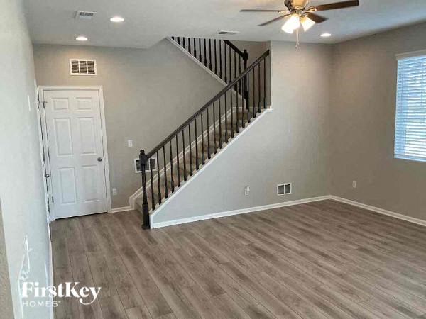 a living room with a staircase and a ceiling fan