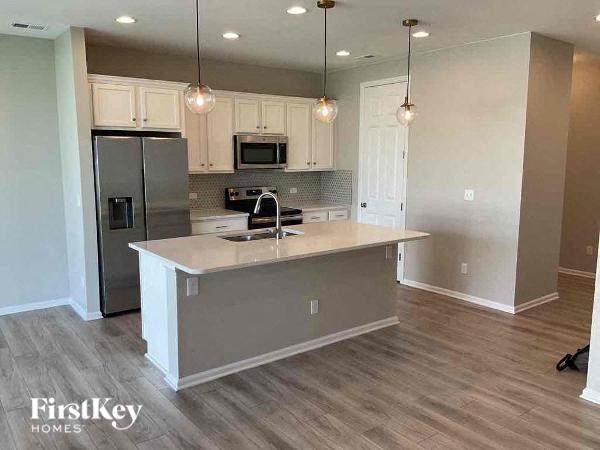 an empty kitchen with a sink and a refrigerator