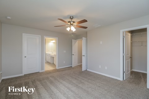 A spacious room with a ceiling fan and a carpeted floor.
