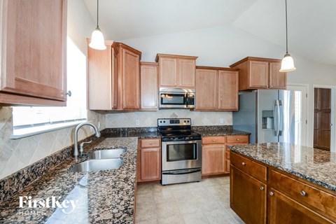 A kitchen with wooden cabinets and granite countertops.