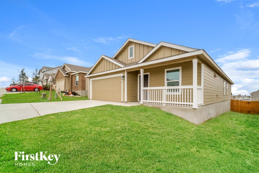 A house with a garage and a car parked in the driveway.