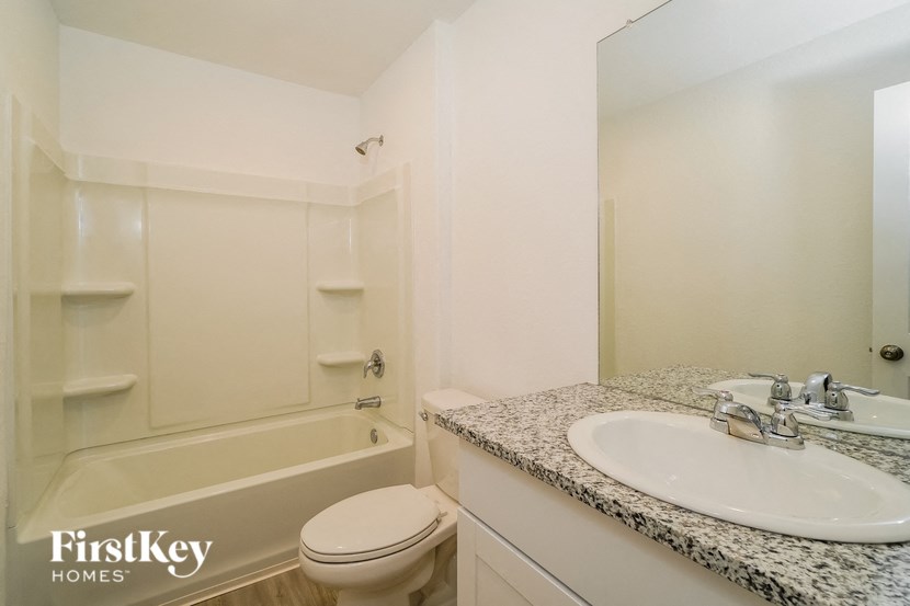 A white bathroom with a tub, toilet and sink.