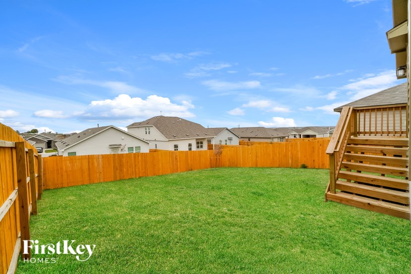 A backyard with a wooden fence and a wooden deck.