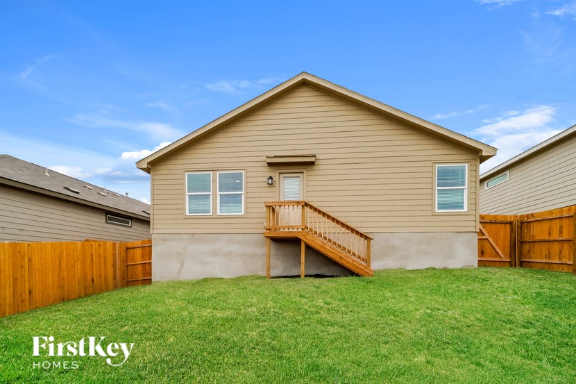 A house with a brown siding and a wooden fence.