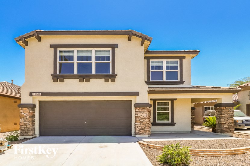 a beige house with a garage and a driveway