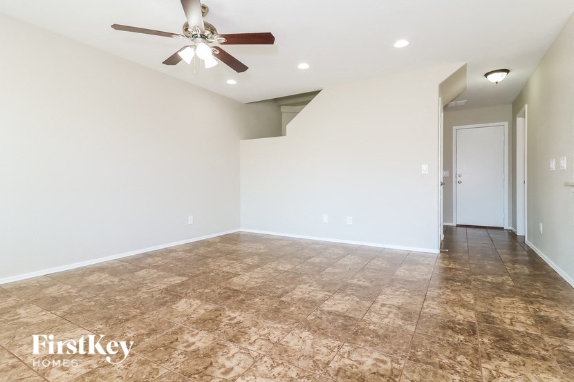 a empty living room with a ceiling fan