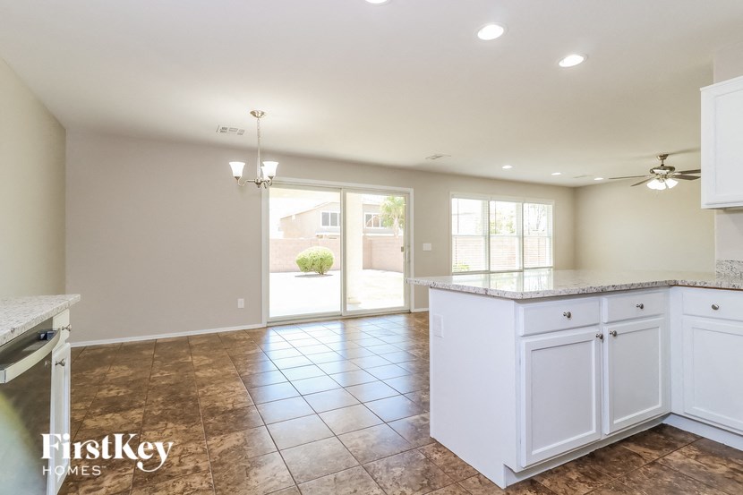 an empty kitchen with white cabinets and a counter top
