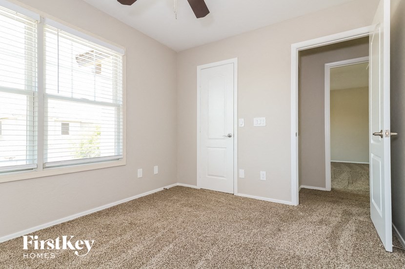 a bedroom with a door and a window and a carpeted floor