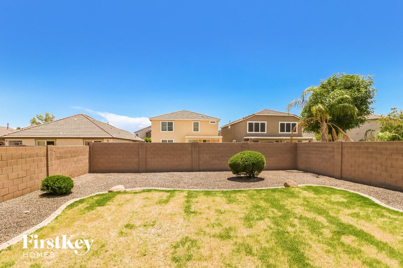 a backyard with a fence and houses in the background
