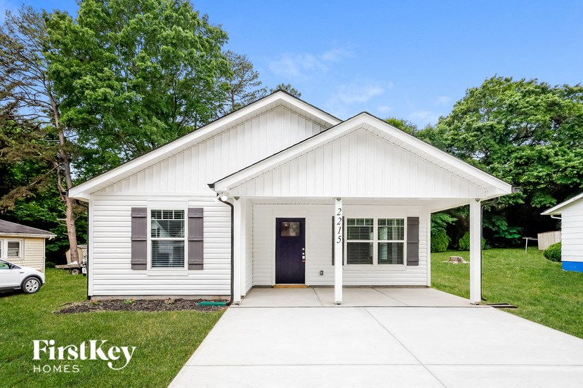 the exterior of a white house with a driveway