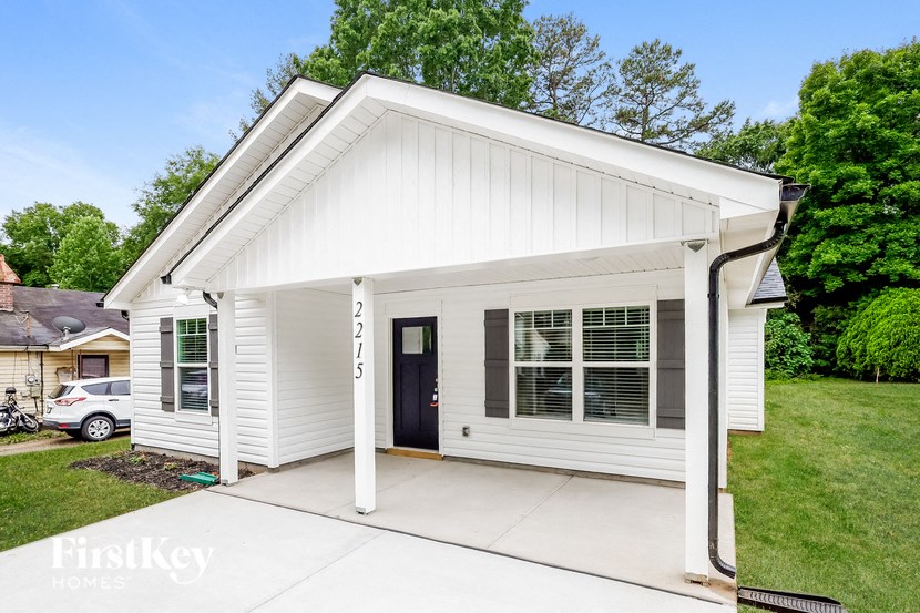 the front of a white house with a driveway
