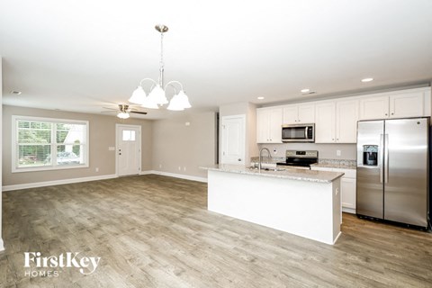 a kitchen with a large island and a stainless steel refrigerator