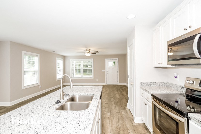 a kitchen with a sink and a stove and a microwave