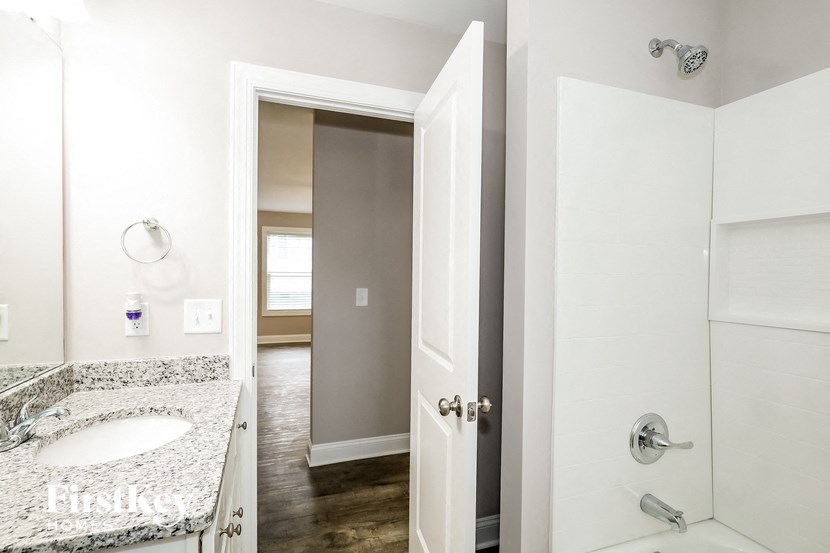 a bathroom with a sink and a shower and a mirror