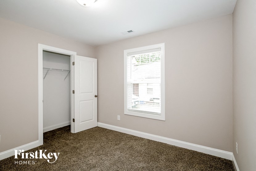 a bedroom with a closet and a window and a door