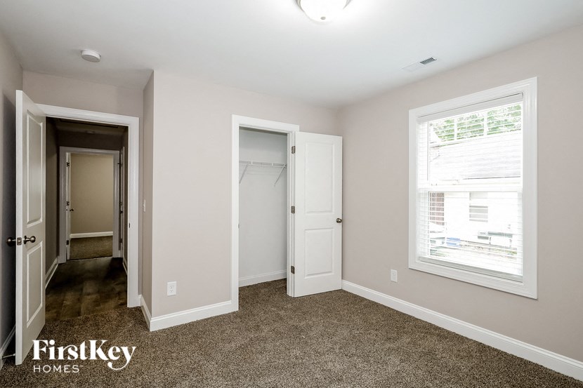 a bedroom with a door to a closet and a window