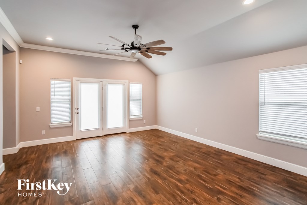a living room with wood floors and a ceiling fan