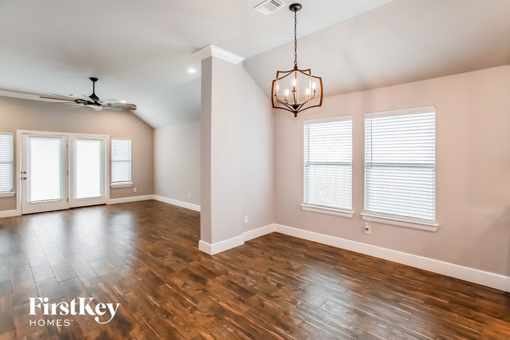 an empty living room with wood floors and a light fixture
