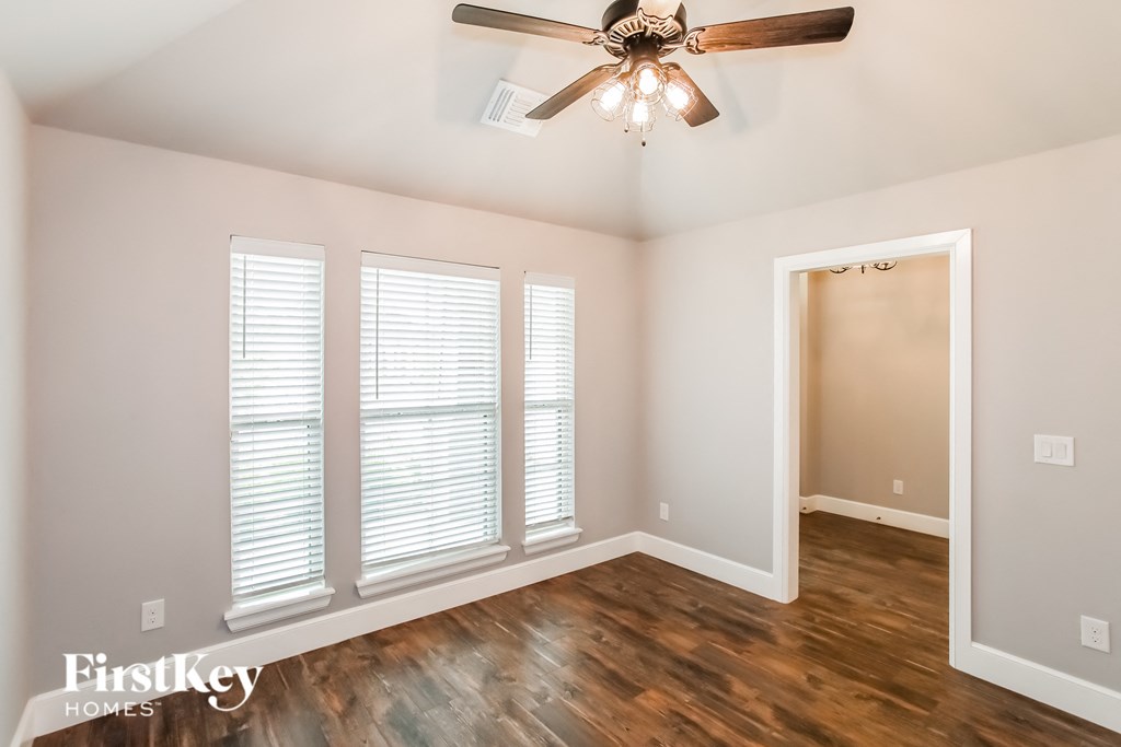 a living room with wood floors and a ceiling fan