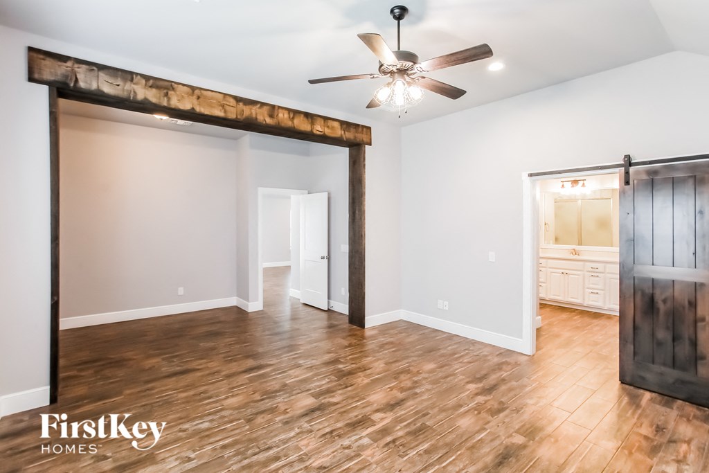 a living room with a wood floor and a sliding barn door