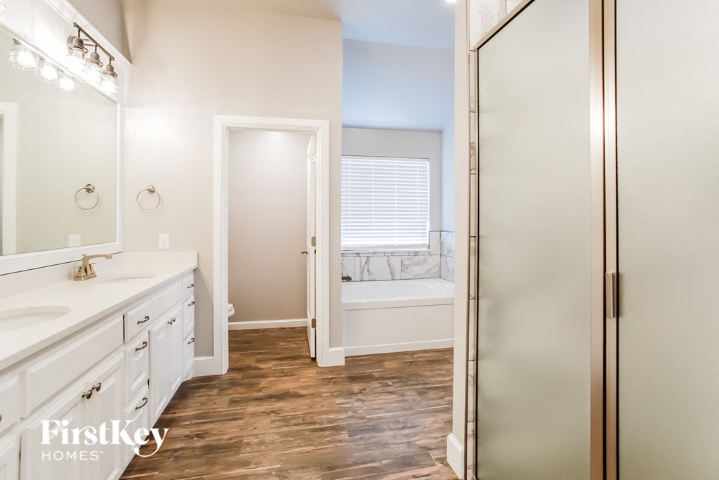 a bathroom with a large mirror and a tub and a sink