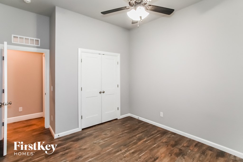 a bedroom with a closet and a ceiling fan