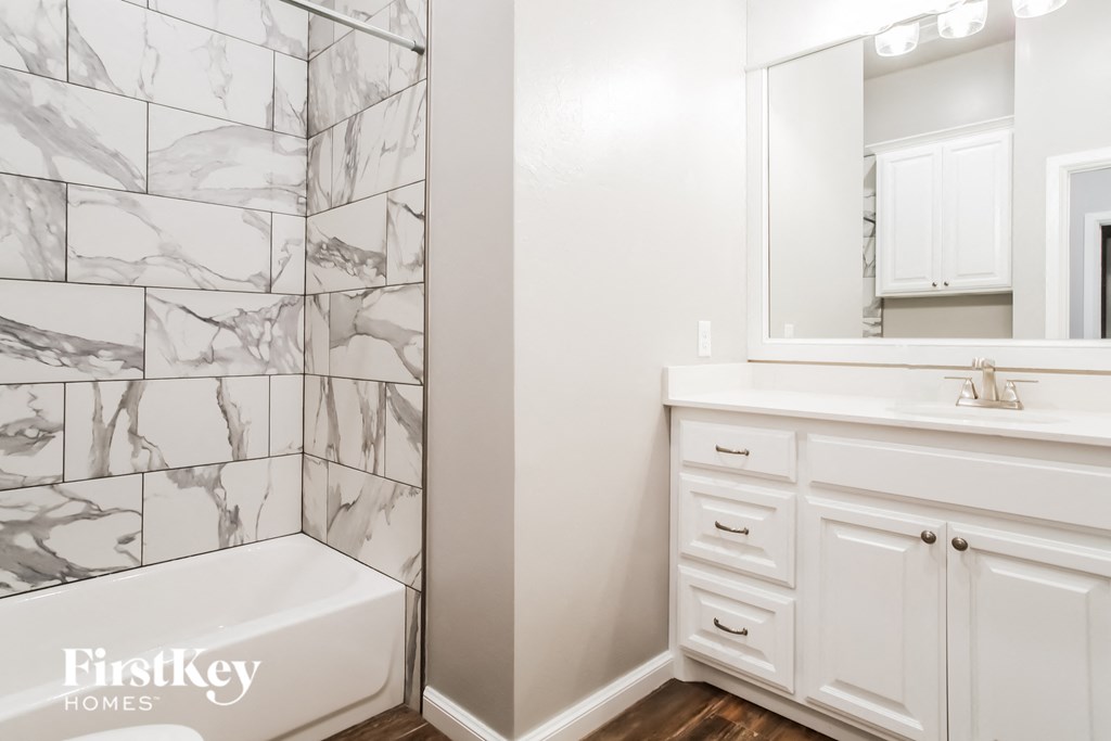 a bathroom with a tub and a sink and a mirror