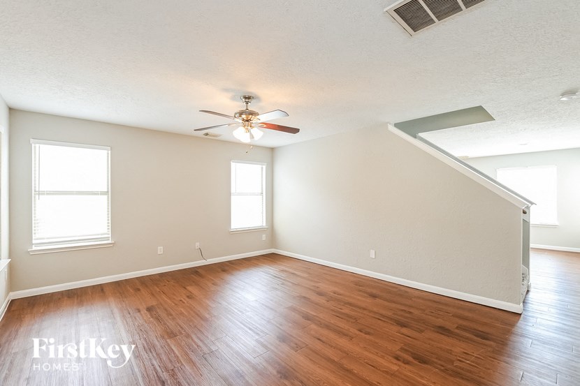 a living room with hardwood floors and a ceiling fan