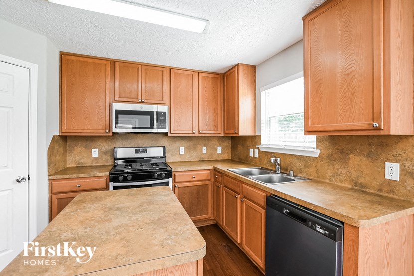 a kitchen with wooden cabinets and a sink and a stove