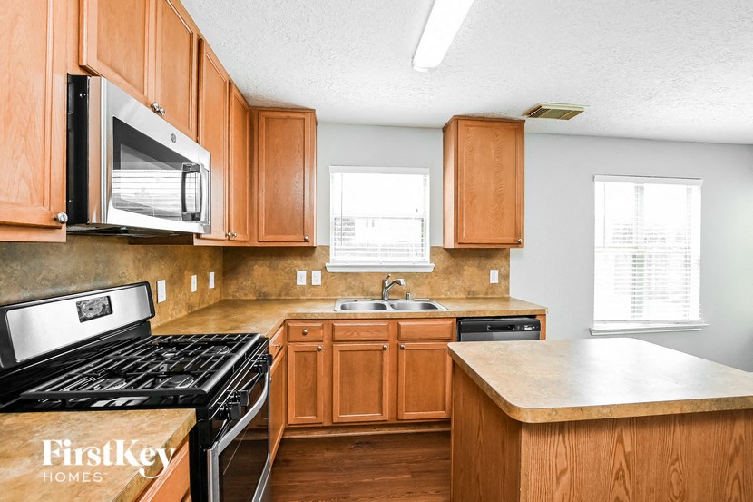a kitchen with wooden cabinets and a stove and a microwave